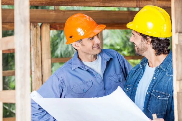 Arquitectos sonrientes discutiendo sobre el proyecto en el sitio —  Fotos de Stock