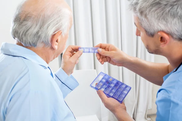 Gardien montrant la médecine d'ordonnance à l'homme âgé — Photo