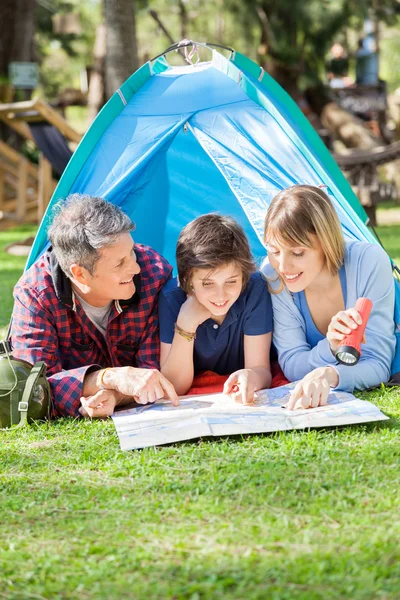 Glad familj läsa karta i tält — Stockfoto