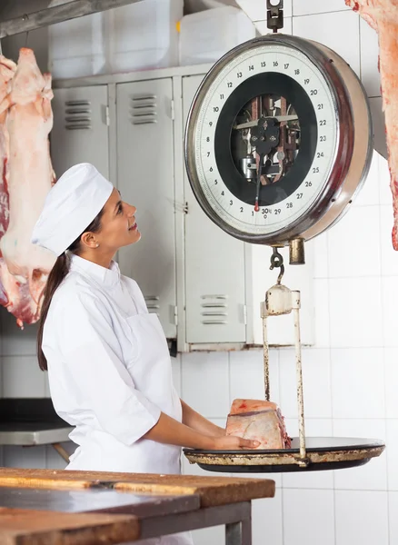 Macellaio femminile che pesa carne in macelleria — Foto Stock