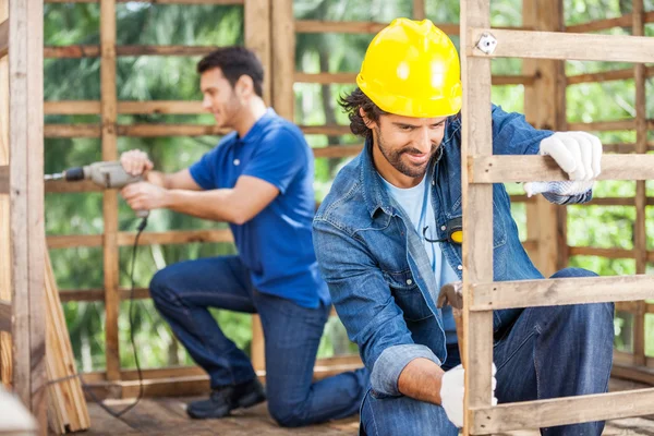 Travailleurs travaillant dans la cabine en bois sur le site — Photo