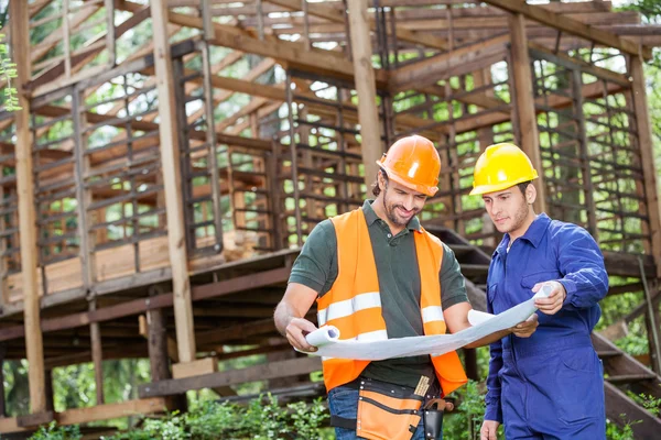 Ingenjörer analysera Blueprint utanför trä stuga — Stockfoto