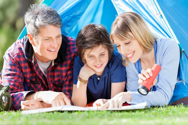 Familjen tittar på karta i tält — Stockfoto