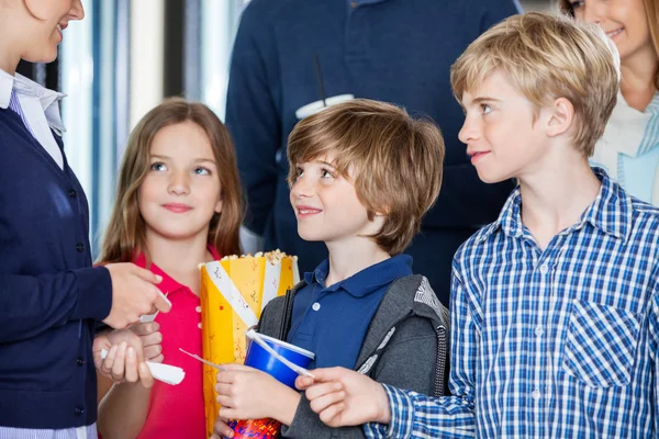 Trabajador chequeando entradas de familia en el cine — Foto de Stock