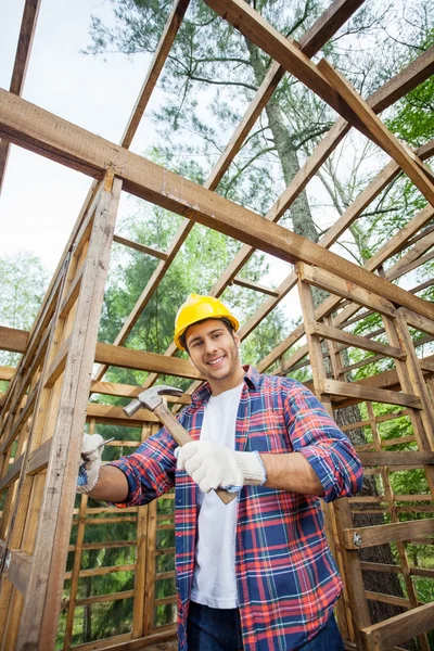 Smiling Construction Worker Hammering In Timber Cabin — Stock Photo, Image