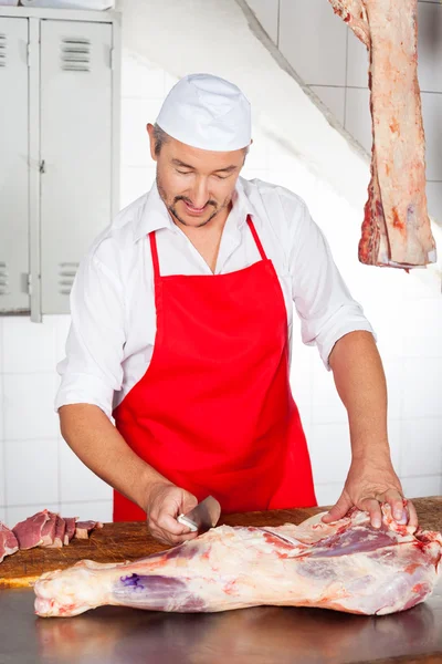 Metzger schneidet Fleisch an der Theke — Stockfoto