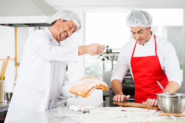 Улыбающиеся повара готовят пасту Равиоли вместе на кухне — стоковое фото