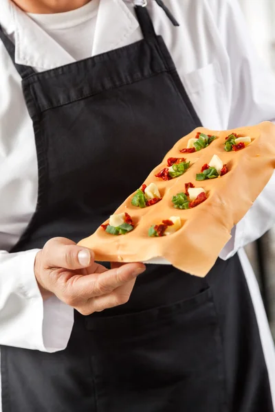 Männlicher Koch hält Tablett mit gefüllten Ravioli-Nudelblättern — Stockfoto