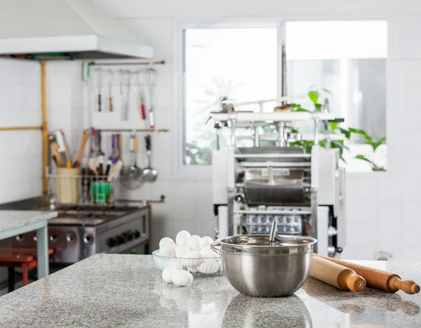 Cuenco de mezcla con huevos y rodillo enrollable en la cocina comercial —  Fotos de Stock