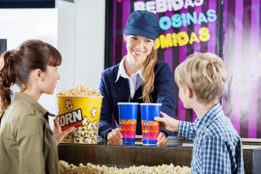 Brother And Sister Buying Popcorn From Seller In Cinema clipart