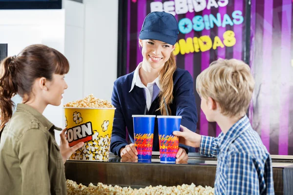 Hermano y hermana comprando palomitas de maíz al vendedor en el cine — Foto de Stock