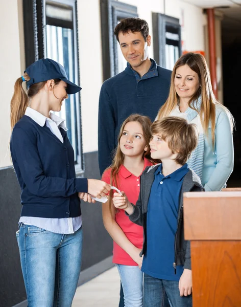 Werknemer onderzoeken Tickets van familie in bioscoop — Stockfoto