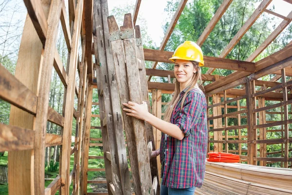 Vrouwelijke werknemer houden Ladder In houten cabine tijdens bouw Sit — Stockfoto