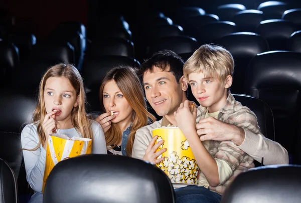 Familjen äter Popcorn medan du tittar på Film i teater — Stockfoto