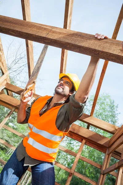 Trabajador de la construcción de corte de madera con sierra manual en el sitio —  Fotos de Stock