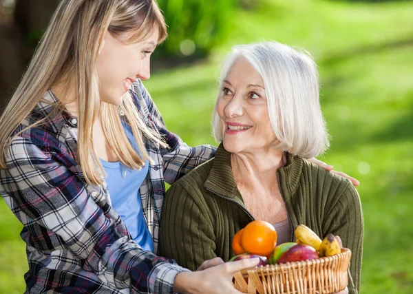 Daughter And Mother Holding Fruit Basket At Campsite — Stock Photo, Image