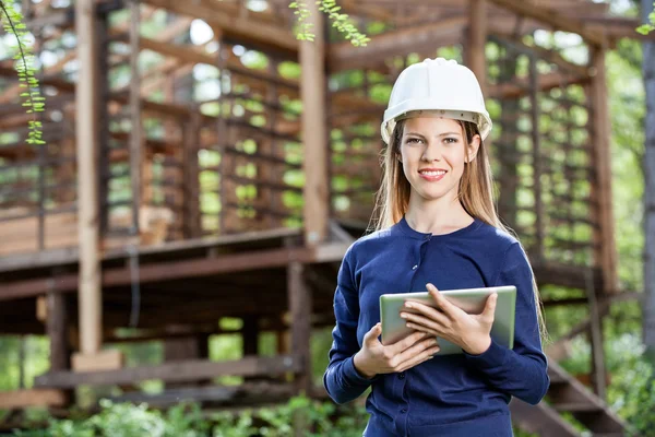 Lächelnde Architektin mit digitalem Tablet vor Ort — Stockfoto