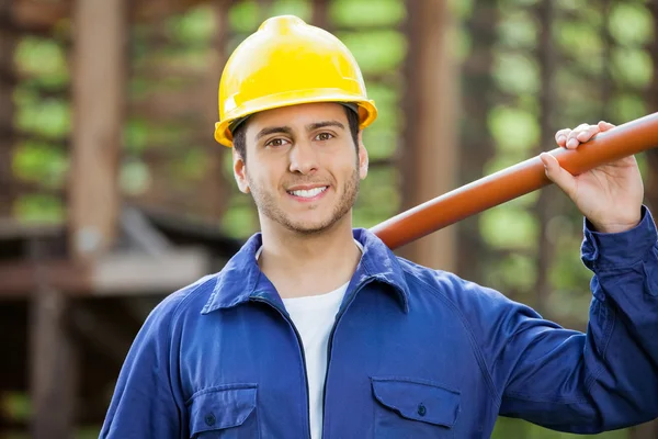 Glücklicher Bauarbeiter mit Rohr — Stockfoto