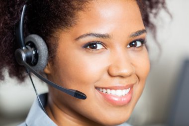 Closeup Of Smiling Female Customer Service Representative Wearin