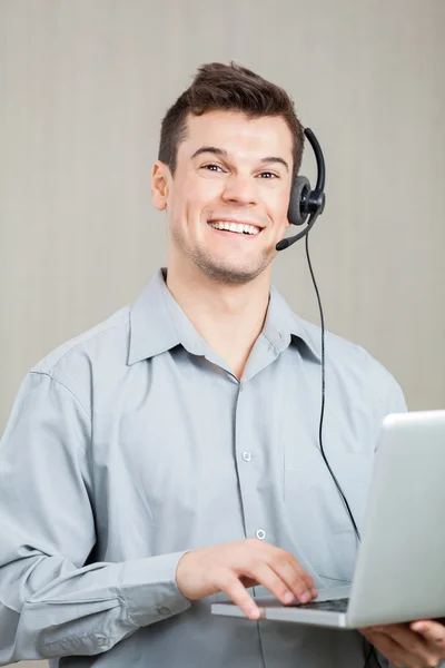 Männlicher Callcenter-Mitarbeiter mit Laptop — Stockfoto