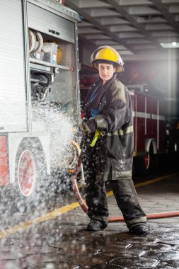 Kendinden emin Firewoman antrenman sırasında su püskürtme