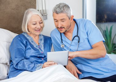 Hemşire kadın kıdemli ile dijital Tablet üzerinde tartışıyor
