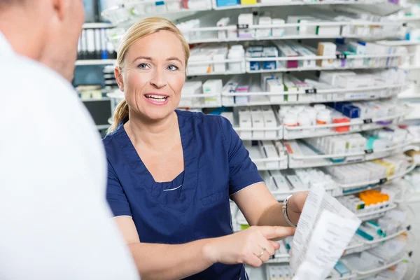 Femme pharmacien expliquant les détails du produit au client — Photo