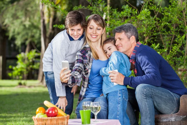 Familjen som självporträtt genom Smartphone på campingplats — Stockfoto