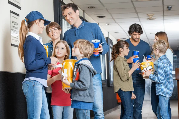 Trabajadora con familias en el cine — Foto de Stock