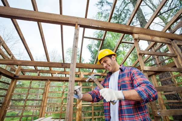 Smiling Worker Hammering Nail On Timber Cabin — Stock Photo, Image