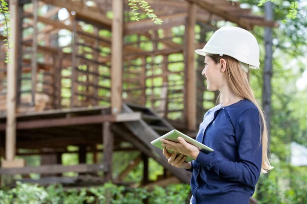 Arkitekten håller Digital Tablet medan du tittar på ofullständig Tim — Stockfoto