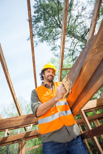 Trabajador de corte de madera con sierra manual en el sitio de construcción — Foto de Stock