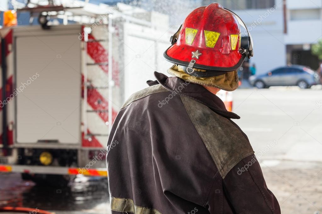 Firefighter Spraying Water At Fire Station