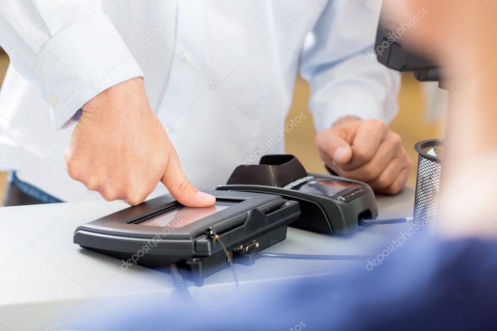 Customer Giving Thumb Impression To Make Payment In Pharmacy