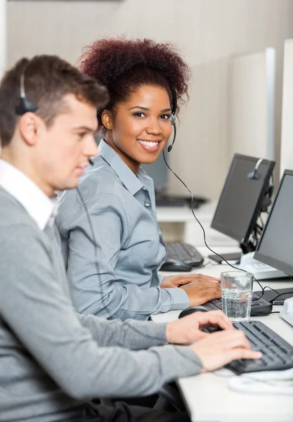 Jeune employé avec collègue masculin travaillant au bureau — Photo