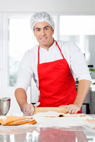 Selbstbewusster Koch rollt Ravioli-Nudelblech in der Küche — Stockfoto
