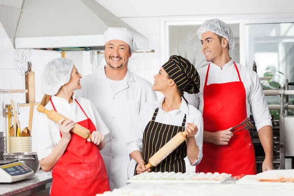 Chefs felizes olhando para o colega na cozinha — Fotografia de Stock