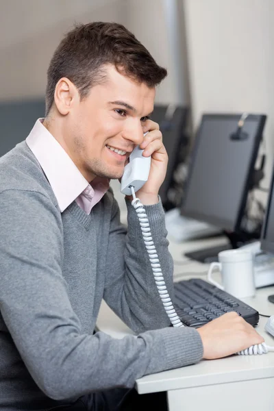 Representante de atendimento ao cliente usando telefone fixo na mesa — Fotografia de Stock