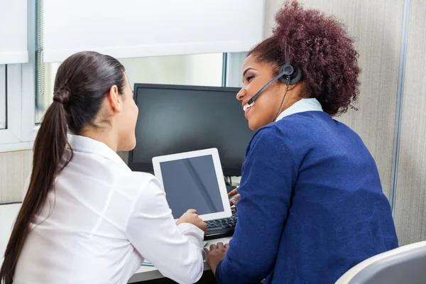 Šťastný Call Center zaměstnanci diskutovat při používání digitálních tabulka — Stock fotografie