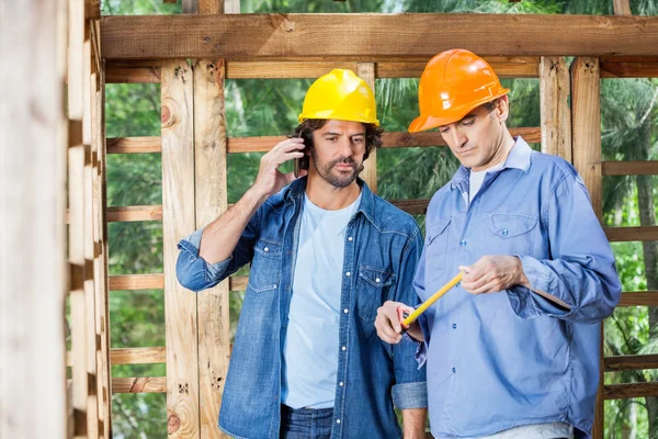Architect Using Mobilephone While Colleague Standing At Site — Stock Photo, Image