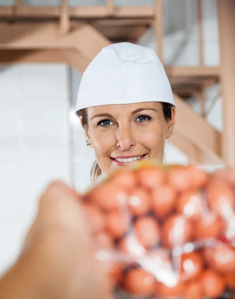 Happy slaktare säljer förpackade korv till kund — Stockfoto