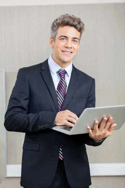 Confident Businessman Using Laptop Stock Photo