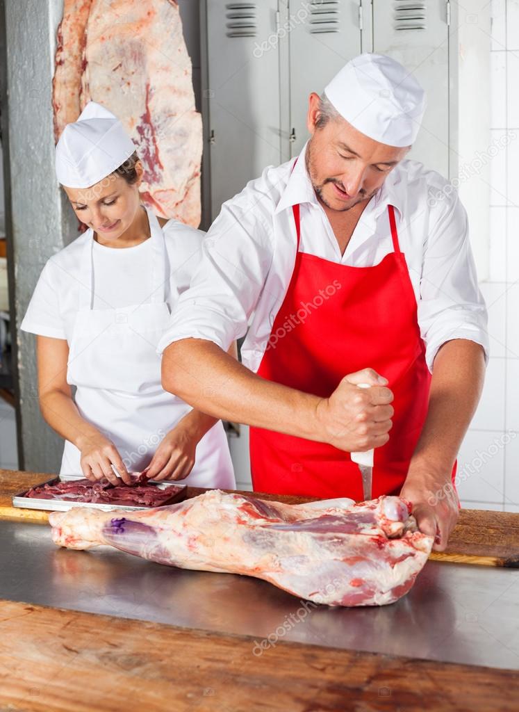 Butchers Working At Counter In Butchery