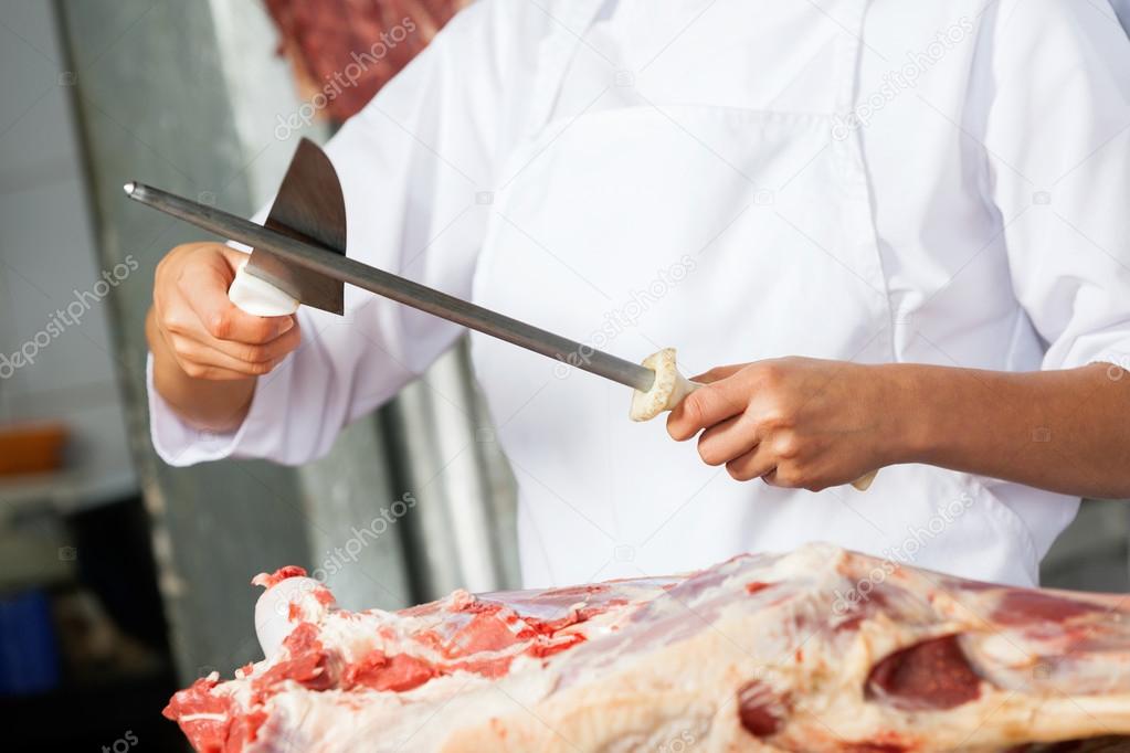 Female Butcher Sharpening Knife In Butchery