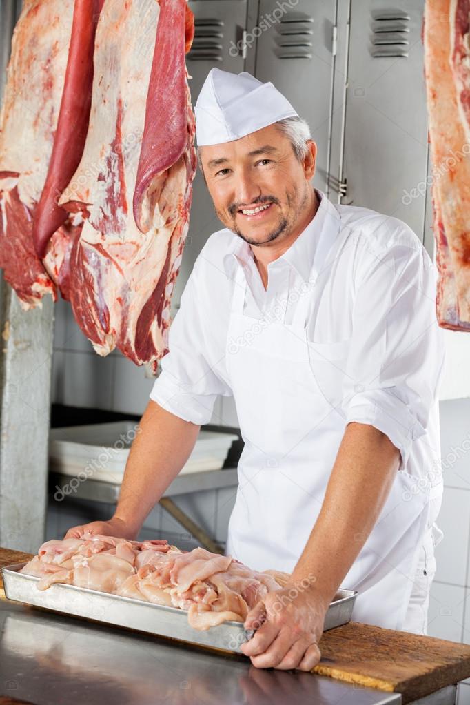 Confident Butcher With Chicken Pieces On Table