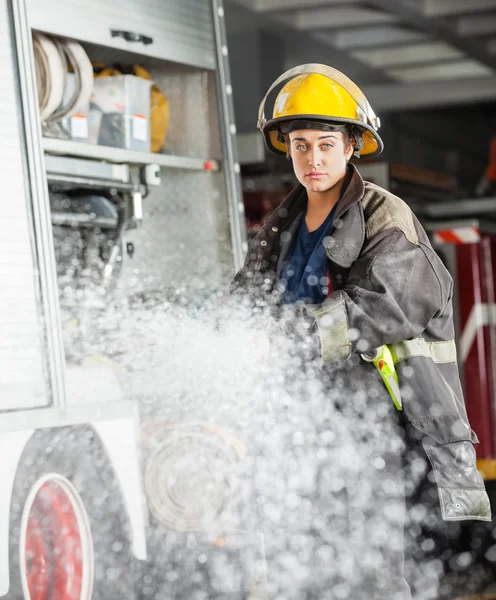 Pewnie Firewoman rozpylanie wody w straży pożarnej — Zdjęcie stockowe