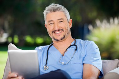 Tablet bilgisayar ile erkek doktor gülümseyen