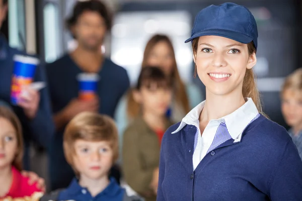 Mooie werknemer met gezinnen In achtergrond bij Cinema — Stockfoto