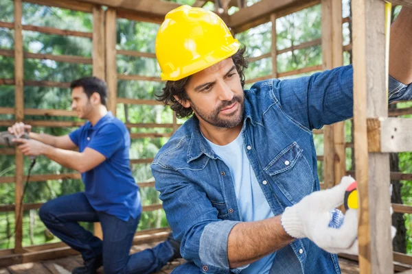 Mannelijke timmerlieden werken op bouwterrein — Stockfoto