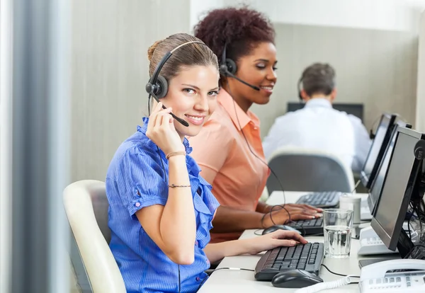 Jonge gelukkig medewerker van de klantenservice via Headset In uit — Stockfoto